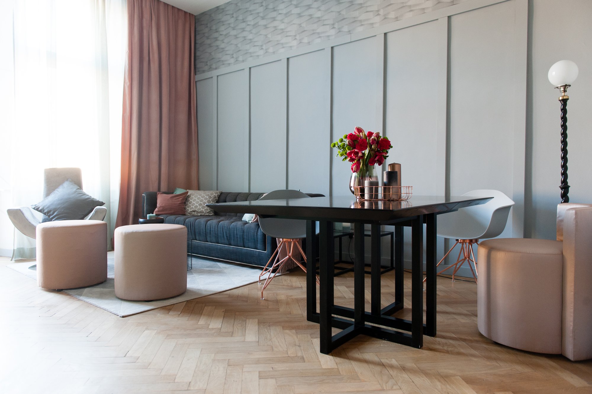 LAROGY · Wohnzimmer in einem Wiener Gründerzeithaus, Fischgrätparkett, vergoldete Wandvertäfelung, Vintage-Sessel, Messing-Stehlampe