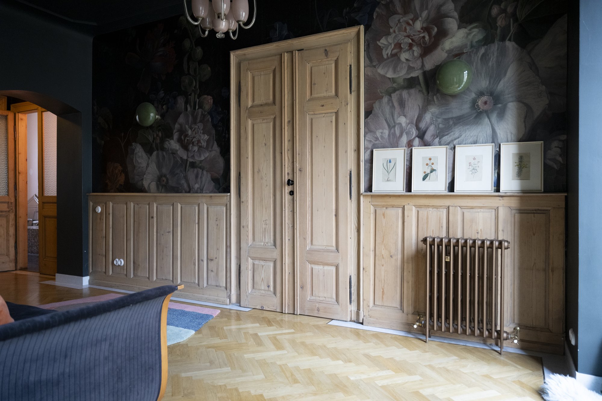 Maison LAROGY · Vintage-Wohnzimmer in Wien mit Samtsesseln, Wandvertäfelung und Messing-Stehlampe